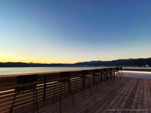 a row of chairs sitting on top of a pier at Rako Hananoi Hotel in Suwa