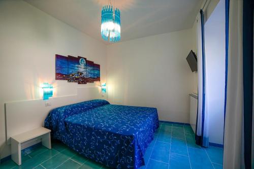 um quarto com uma cama azul num quarto em Ncopp' a' Scalinatella em Scala