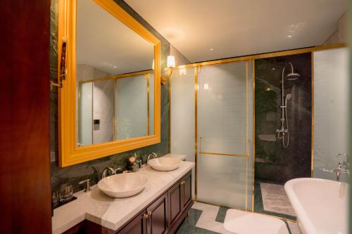 a bathroom with two sinks and a shower at Regal Collection House in Dương Cảnh