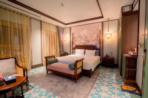 a bedroom with a bed and a chair and a couch at Regal Collection House in Dương Cảnh