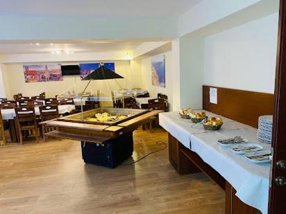 a restaurant with two tables and a piano in a room at Hotel INTERNATIONAL Ohrid in Ohrid