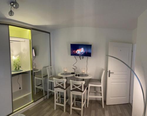 a dining room with a table and chairs at Superbe Appartement en Résidence T3,Options Clim et parking, lave-linge in Bagneux