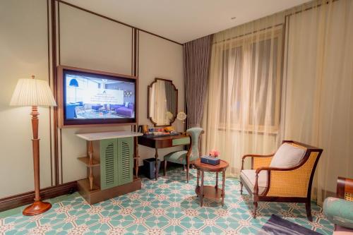 a hotel room with a television and a table and chairs at Regal Collection House in Dương Cảnh