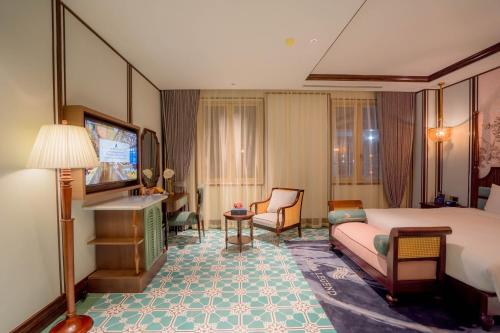 a hotel room with a bed and a television at Regal Collection House in Dương Cảnh