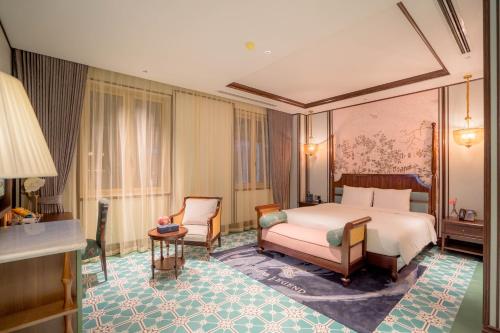 a hotel room with a bed and a chair at Regal Collection House in Dương Cảnh