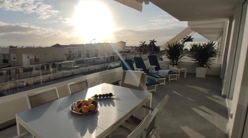 a balcony with a table and chairs on a roof at Costa Adeje Ocean View Apartment in Adeje