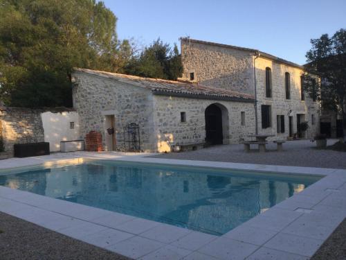 une villa avec piscine devant un immeuble dans l'établissement Maison de maître cévenol, à Moulézan