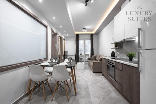 a kitchen and living room with a table and chairs at Adelle Apartments, The Luxury Suites in Thessaloniki