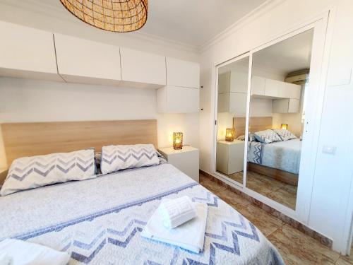 a bedroom with a large bed and a mirror at Marina View Apartment in Fuengirola