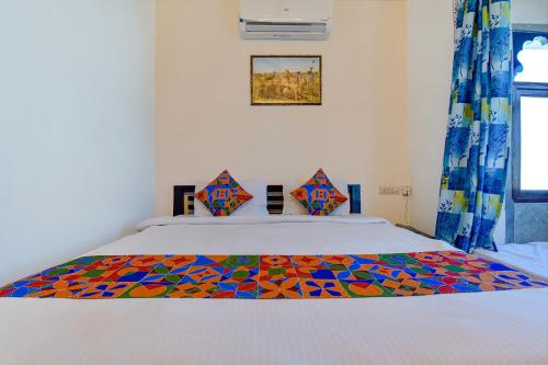 a bedroom with a bed with a colorful blanket on it at FabExpress Achrol Palace in Udaipur