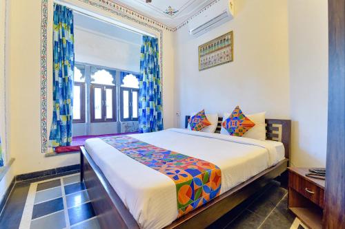 a bedroom with a bed and a window at FabExpress Achrol Palace in Udaipur
