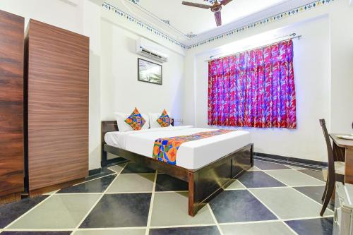 a bedroom with a bed and a window at FabExpress Achrol Palace in Udaipur