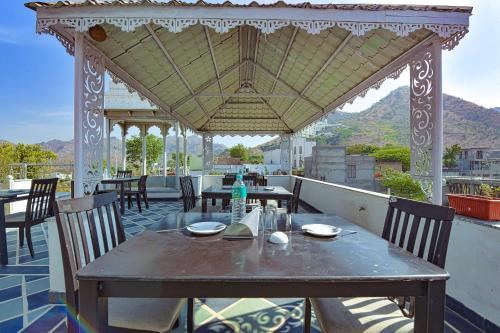 a table and chairs on a patio with a gazebo at FabExpress Achrol Palace in Udaipur