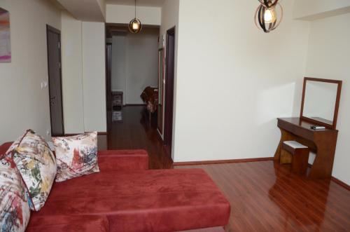 a living room with a red couch and a mirror at Hotel INTERNATIONAL Ohrid in Ohrid