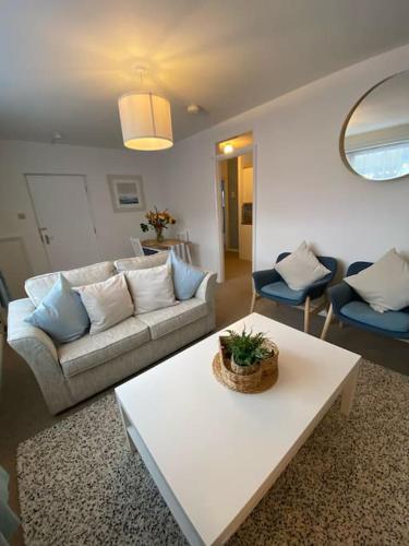 a living room with a couch and a table at Eremue Court Hideaway Yarmouth IOW in Yarmouth