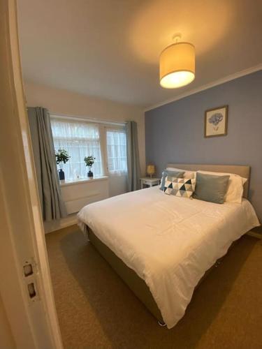 una camera da letto con un grande letto bianco e una finestra di Eremue Court Hideaway Yarmouth IOW a Yarmouth