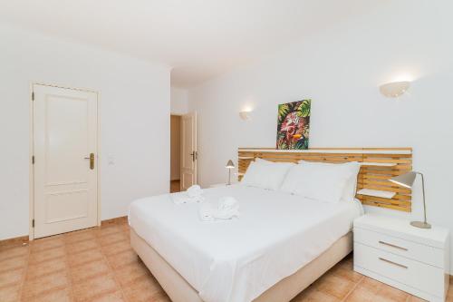 Dormitorio blanco con cama grande y lámpara en Algarve Golden Properties: Casa da Galé, en Lagos