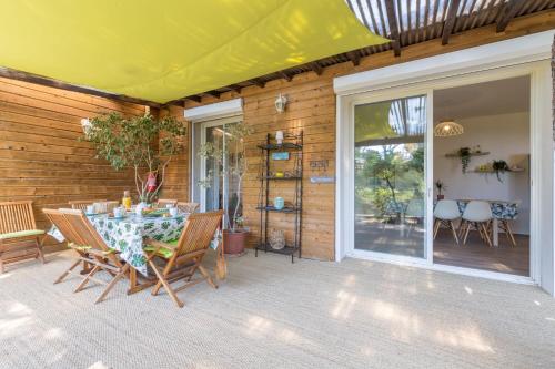 un patio avec une table et des chaises sur un porche dans l'établissement La Félyvonne, villa familiale confortable avec sa grande terrasse ombragée et sa vue dégagée vers la mer, à Hyères