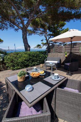une table avec de la nourriture dessus sur une terrasse dans l'établissement Le Bastidon, charmant studio 2 pers avec vue mer, idéalement situé, à Hyères