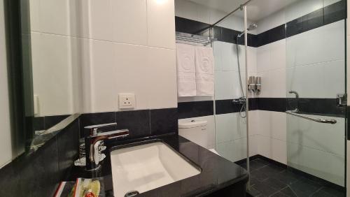 a bathroom with a sink and a shower at d'primahotel Lagoi Bintan in Lagoi