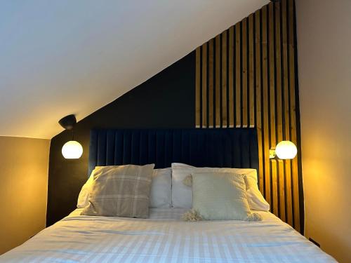 a bedroom with a large bed with two lights on it at The Valentine - Townhouse Hotel in Edinburgh