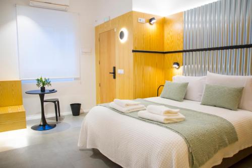 a bedroom with a large bed with towels on it at KALIDAS HOSTEL SUITES in Caldas de Reis