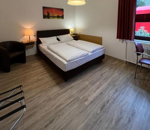 Schlafzimmer mit einem Bett, einem Schreibtisch und Stühlen in der Unterkunft Hotel Columbus und Glamping in Bremerhaven