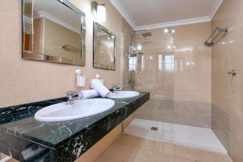 a bathroom with two sinks and a shower at Villa Flavia-private pool, jacuzzi, sea views in Playa Blanca