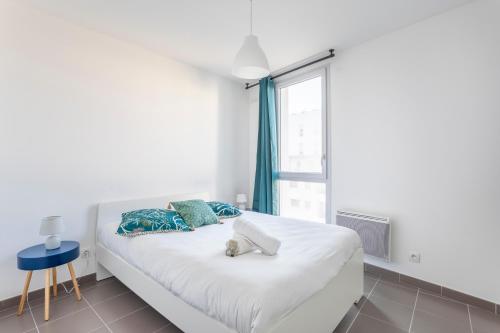 Cama blanca en habitación con ventana en NEW JOLIETTE Comfortable Apartment well located with private parking, en Marsella