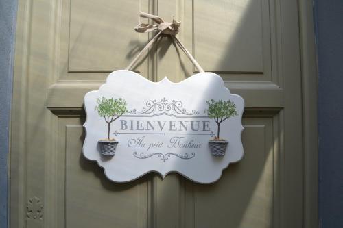un panneau suspendu à une porte avec trois arbres dans l'établissement L'Escapade 3 étoiles, à Champagne-sur-Seine