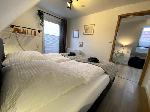 a large bed in a bedroom with a large window at Ferienhaus Kiebitznüst in Emden in Emden