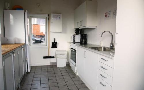 a small kitchen with white cabinets and a sink at Harbour Sleep in Neksø
