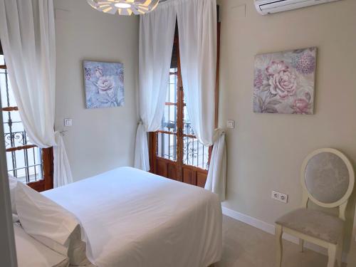 a bedroom with a white bed and a window at Apartamento Arquillo de la Plata in Seville
