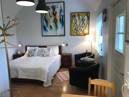 a bedroom with a white bed and a chair at TOBSBORG 2 in Simrishamn
