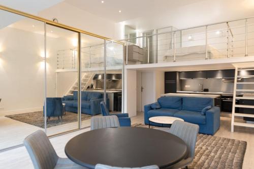 un salon avec une table et des chaises bleues dans l'établissement Paris 15th - Residence Loft Duplex 4 Pers - Metro, à Paris