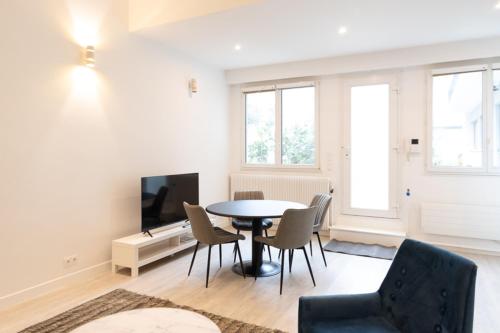 - un salon avec une table, des chaises et une télévision dans l'établissement Paris 15th - Residence Loft Duplex 4 Pers - Metro, à Paris