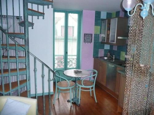 a kitchen with a table and chairs in a room at Gîte Milly - 2 studios en coeur de ville in Milly-la-Forêt