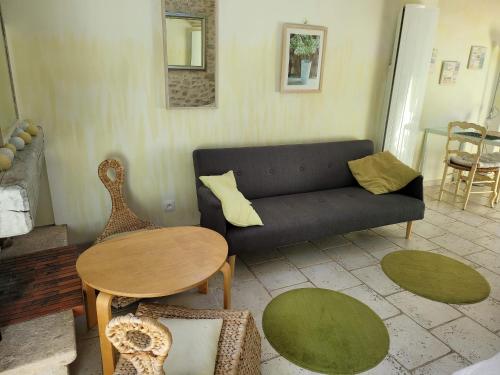 een woonkamer met een bank en een tafel bij Gîte Milly - 2 studios en coeur de ville in Milly-la-Forêt