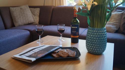 a table with a plate of food and two glasses of wine at Chalet Durbuy 123 in Durbuy