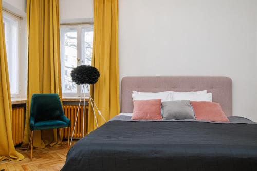 a bedroom with a bed and a green chair at Apartment Peegel in city center free parking in Tallinn