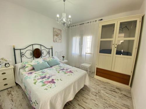 a bedroom with a bed and a chandelier at Hermoso Apartamento Vintage in Cambrils