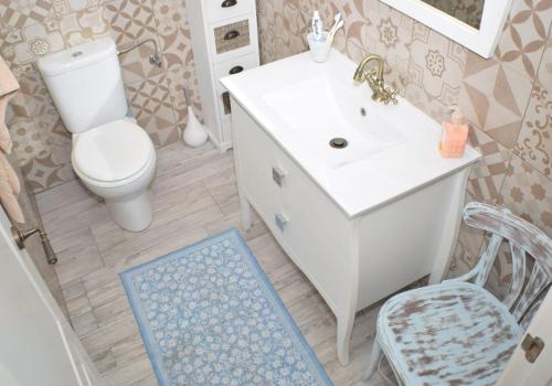 La salle de bains est pourvue de toilettes blanches et d'un lavabo. dans l'établissement Hermoso Apartamento Vintage, à Cambrils