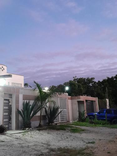 a house with a fence and a car parked next to it at Rooms in Cancun Airport in Cancún