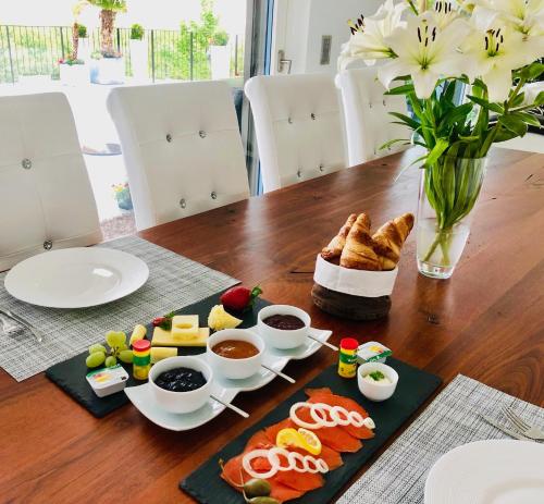 perfect lifestyle Design Boutique & Private SPA في Gebenstorf: طاولة مع طعام و إناء من الزهور