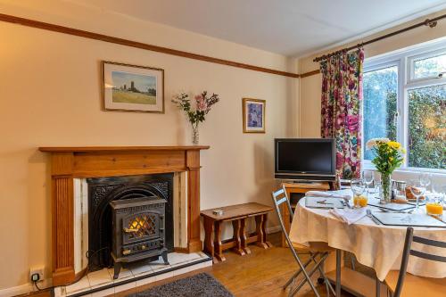 a living room with a table and a fireplace at Finest Retreats - Glebe Cottage in Wellington