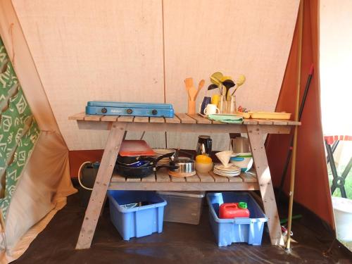 a shelf in a tent with food and utensils at Camping La Forêt du Morvan in Larochemillay