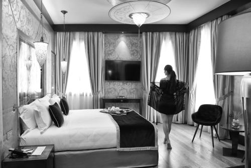 a woman standing in a hotel room with a bed at Santa Croce Boutique Hotel in Venice