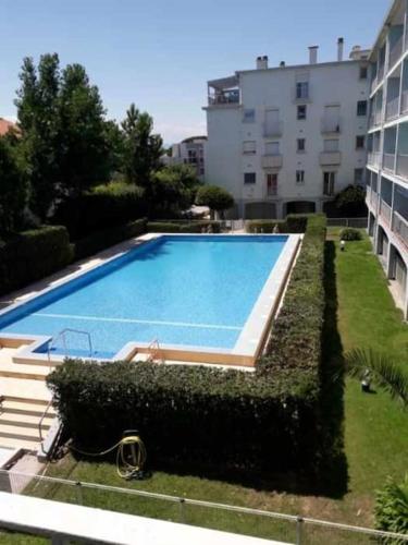 une grande piscine devant un immeuble dans l'établissement Logement tout neuf avec piscine et bord de mer, à Canet
