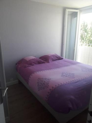 - un lit violet dans une chambre avec fenêtre dans l'établissement Logement tout neuf avec piscine et bord de mer, à Canet