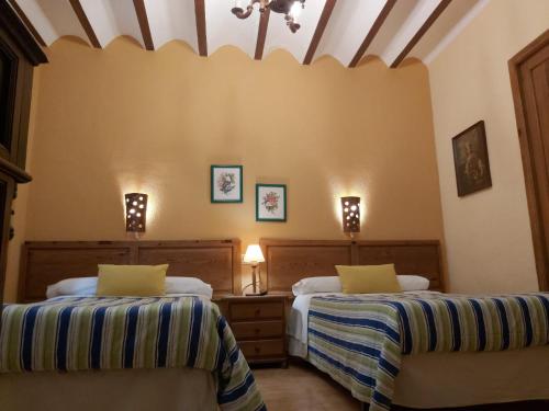 a bedroom with two beds and a ceiling at Apartamentos Tío José María in Hinojares